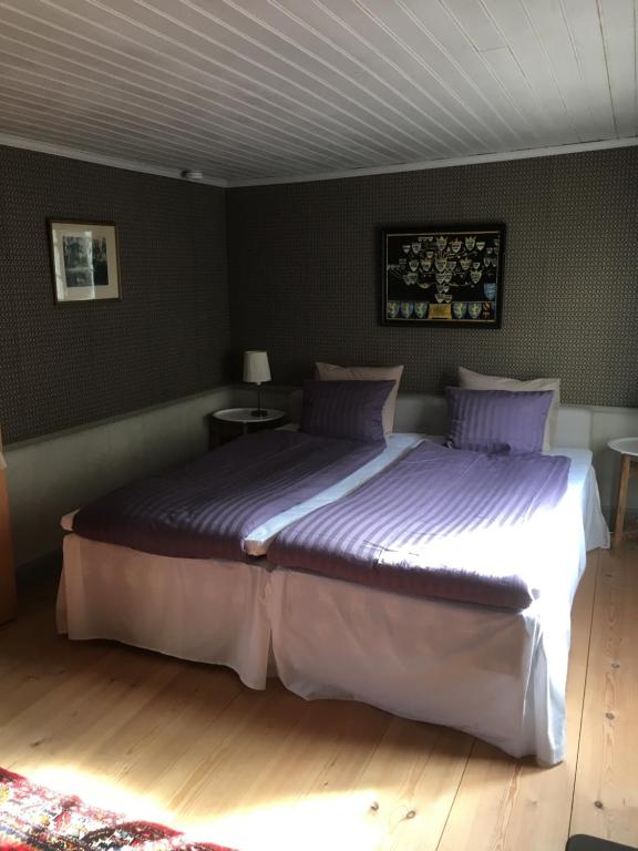a bedroom with a large bed with purple sheets at One Room Bed & Breakfast in Skänninge