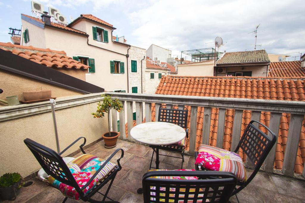 a patio with chairs and a table on a balcony at Jerry & Oli's Apartments in Šibenik