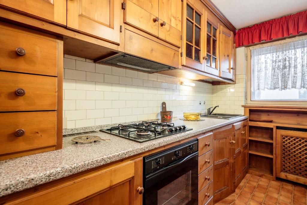 a kitchen with wooden cabinets and a stove top oven at Villa Cristallino -Stayincortina in Cortina dʼAmpezzo