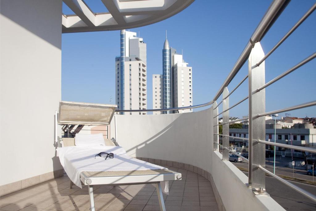 a balcony with a white chair and a view of a city at Residence Speranza in Lido di Jesolo