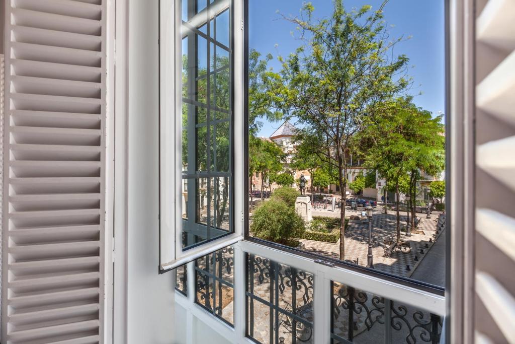 a window that is open in a house at Apartamentos Plaza Pilatos in Seville