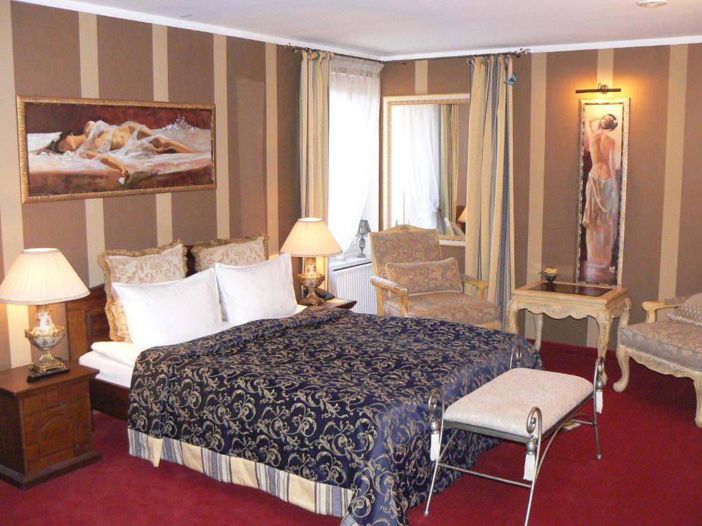 a hotel room with a bed and a chair at Svečių namai Minge in Priekulė