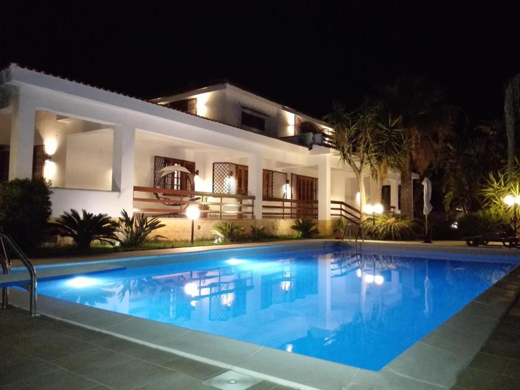 a swimming pool in front of a house at night at Villa Modus Vivendi in Cinisi