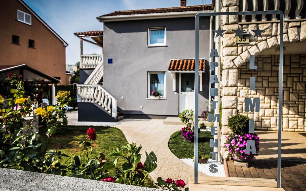 a house with a garden with flowers in front of it at Apartments LIMIA in Pula