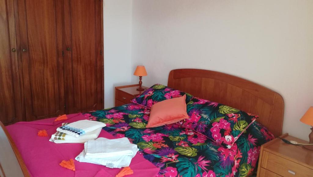 アルジェズールにあるCasa do Polvoの紫色の花のベッドカバーと紙が付いたベッド