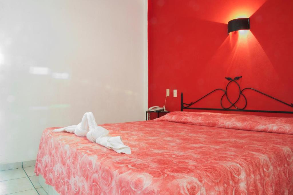 a red bedroom with a bed with a red wall at Hotel El Pacifico in Morelia