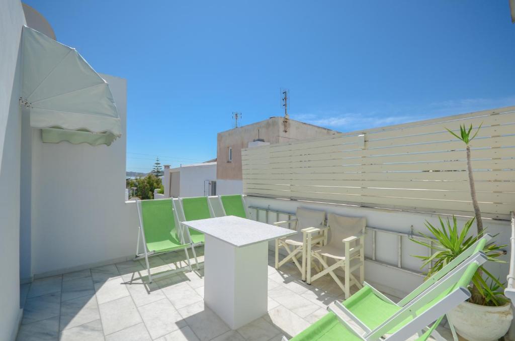 a patio with a table and chairs on a balcony at Windmill Naxos in Naxos Chora