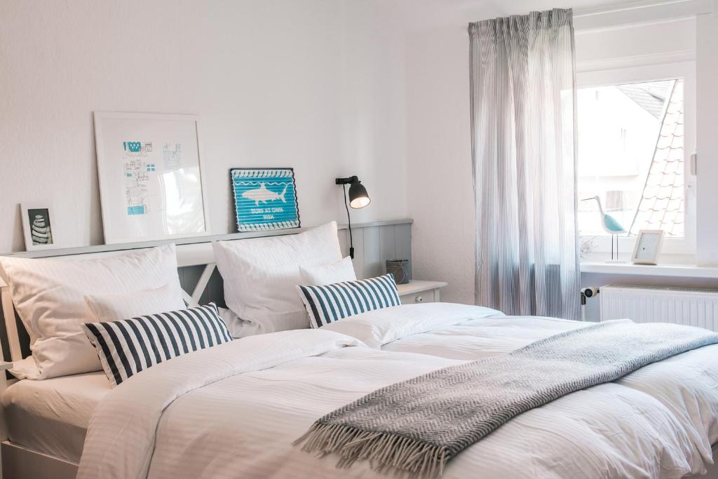 a bedroom with two beds with pillows and a window at Haus Ottenlock in Steinhude