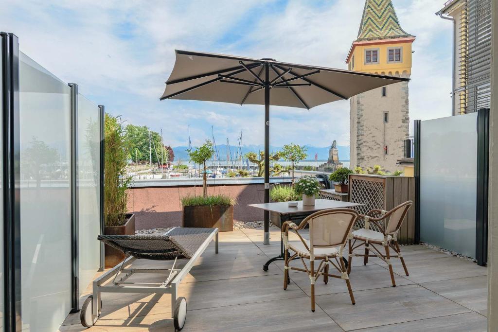 un patio con mesa, sillas y sombrilla en Apartment Hotel Schreier, en Lindau