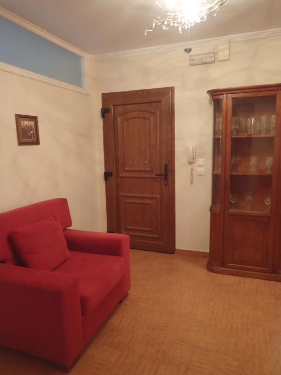 a living room with a red couch and a wooden door at Casa del Centro Storico in Corfu