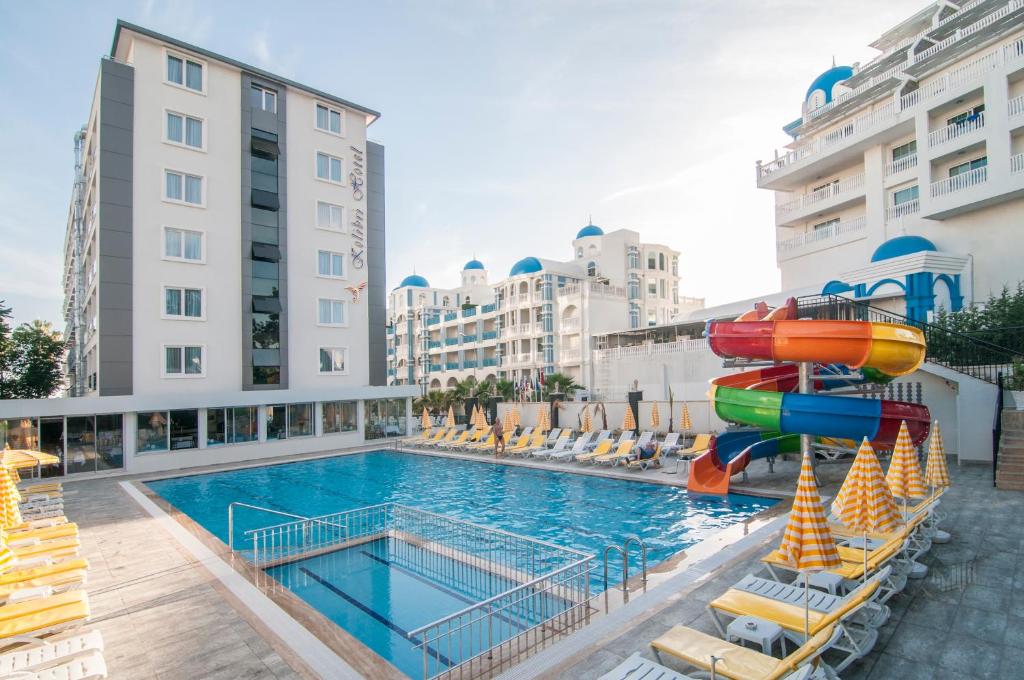 a pool with a water slide on a building at Kolibri Hotel - All Inclusive in Avsallar