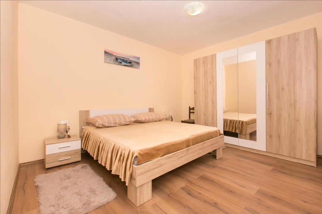 a bedroom with a large bed and a mirror at Old SALONA in Solin