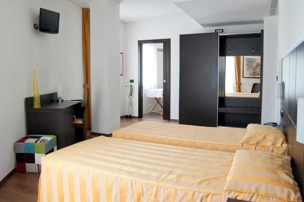En eller flere senge i et værelse på Hotel Leon Bianco