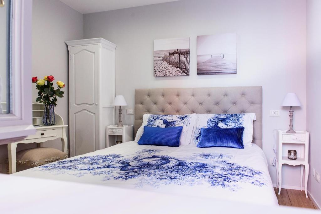 een slaapkamer met een blauw en wit bed met blauwe kussens bij Lora Center Room in Como