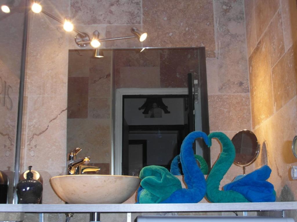 un comptoir de salle de bain avec un lavabo et un miroir dans l'établissement La Baronne Apartment, à Cannes