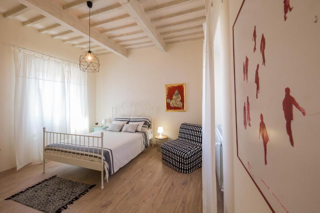 a bedroom with a bed and a chair in it at B&B In Acquaviva in Livorno