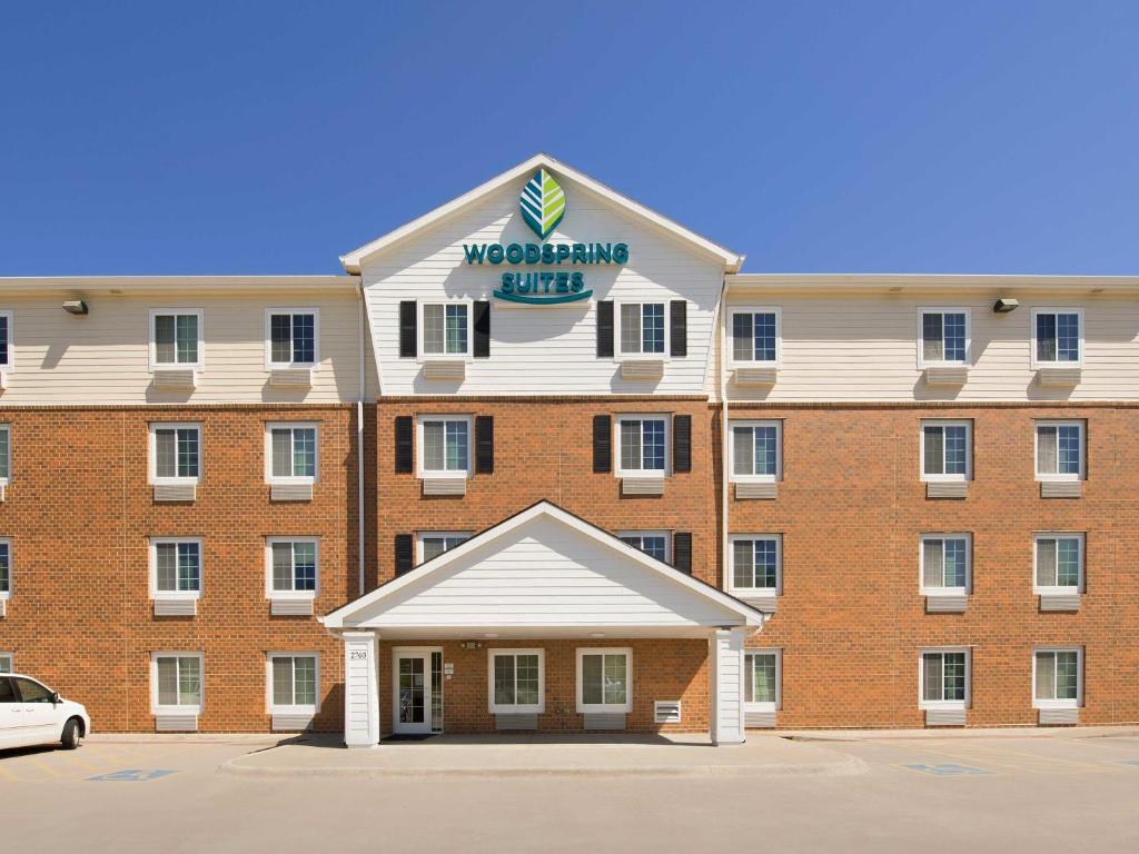 a large red brick building with a sign on it at WoodSpring Suites Omaha Bellevue, an Extended Stay Hotel in Bellevue
