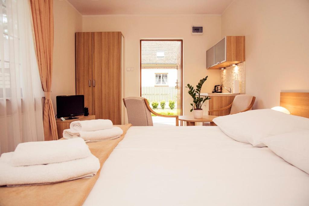 ミエンジボジェにあるUrlop Przy Wydmachのベッドルーム1室(白いシーツとテーブル付きのベッド2台付)