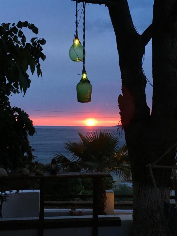 a view of the sunset from a patio with a chandelier at Saranda Hotel in Sarandë