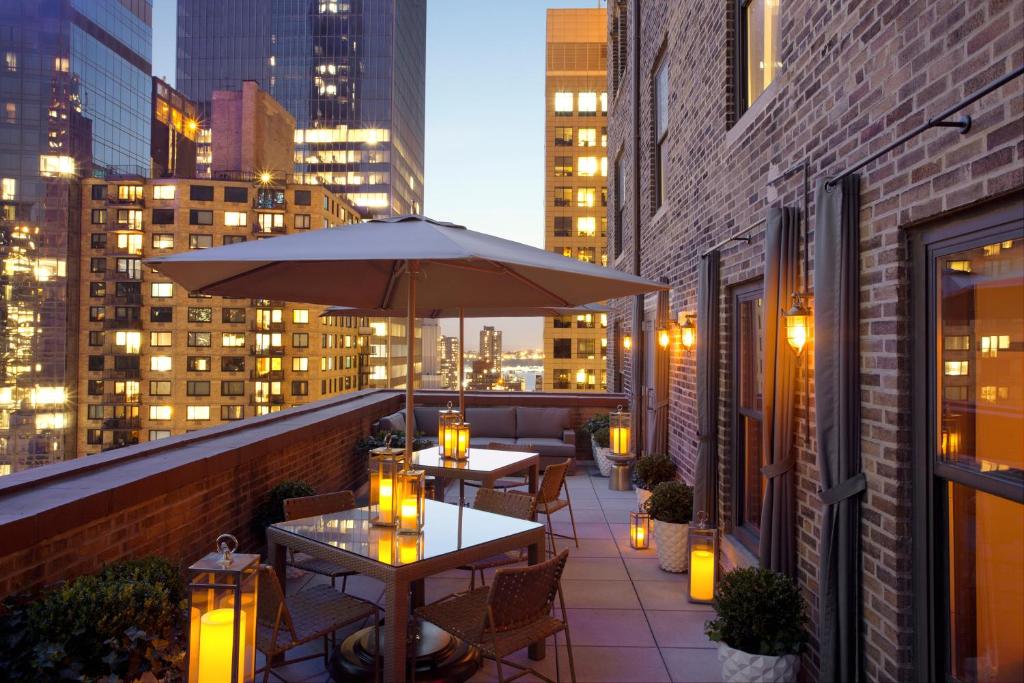 an outdoor patio with tables, chairs and umbrellas at WestHouse Hotel New York in New York