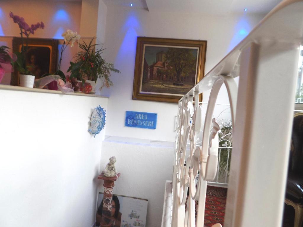 a staircase in a home with a stairwell with flowers and pictures at Hotel Residence Villa Del Mare in Rimini