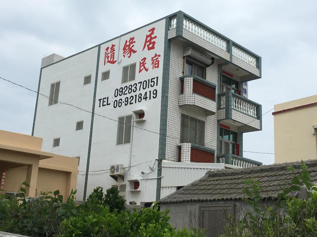 un edificio blanco con un cartel en el costado en 隨緣居, en Huxi