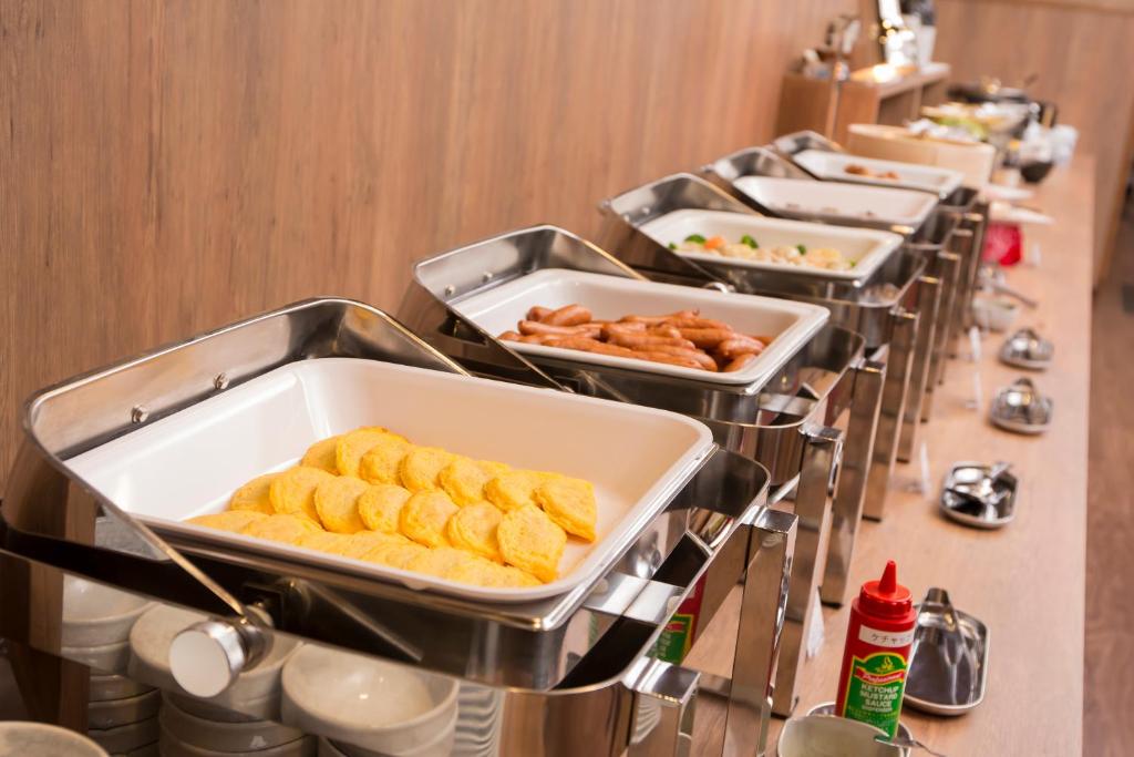 a row of trays of food on a buffet line at Hotel Route-Inn Miyako in Miyako