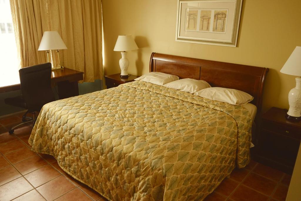 Una cama grande en una habitación de hotel con dos lámparas. en Sea Cove Motel Ocean City, en Ocean City