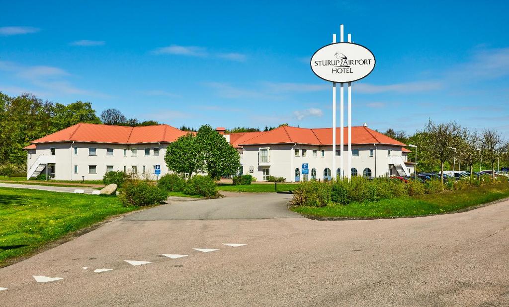 a building with a sign in front of a road at Sturup Airport Hotel in Malmö Sturup