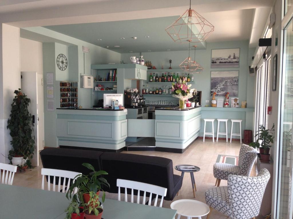 a restaurant with a counter and chairs and a bar at Hotel Ondina e Milazzo in Cervia