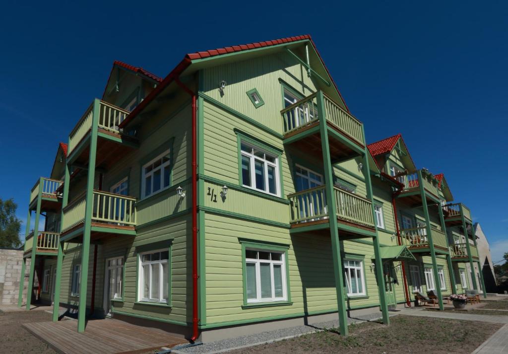un gran edificio verde con balcones. en Qruut Apartments, en Pärnu
