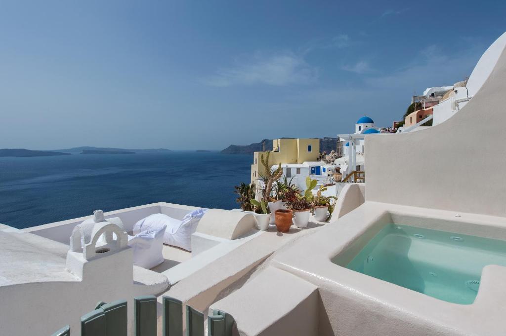 a swimming pool on the side of a white building at Artia Mansion in Oia