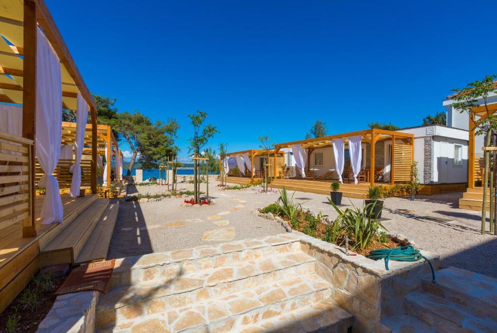 a row of houses with stairs in front of them at Mobile Homes Pine Tree in Dobropoljana