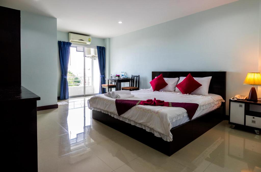 a bedroom with a large bed with red pillows at Raya Rawai Place in Rawai Beach