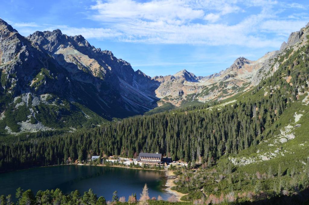 
a lake with mountains and a mountain range at Horský Hotel Popradské Pleso in Štrbské Pleso
