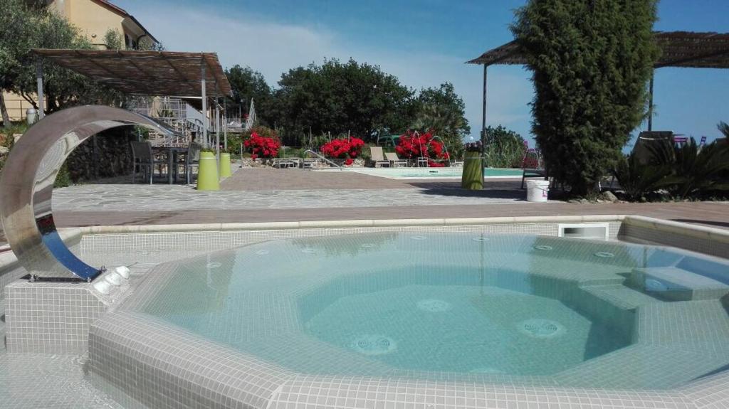 a swimming pool with a jacuzzi tub with a water fall at Oroverde in Bergeggi