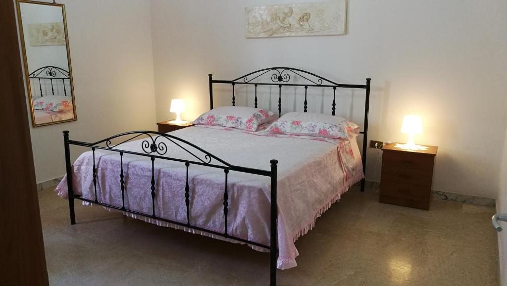 トッレ・サン・ジョヴァンニ・ウジェントにあるCasa Dasy - Torre San Giovanni di Ugento ( Le )のベッドルーム1室(ピンクのシーツとランプ2つ付)