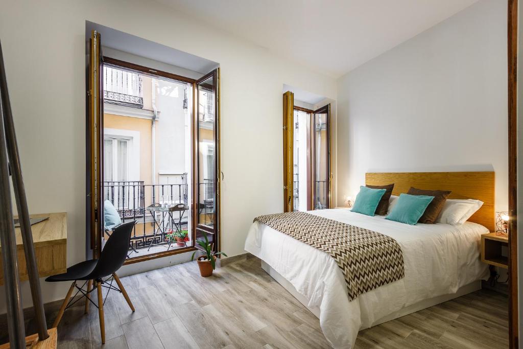 a bedroom with a bed and a large window at Jardines Boutique in Madrid