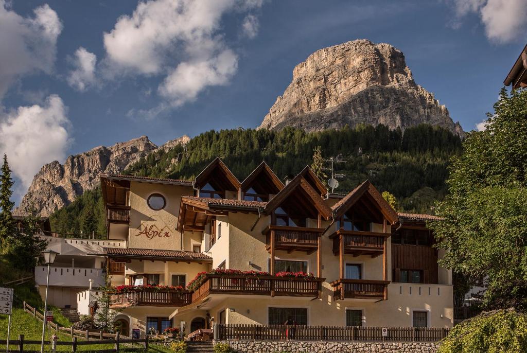 un hôtel avec une montagne en arrière-plan dans l'établissement Alpin Apartments Colfosco, à Colfosco