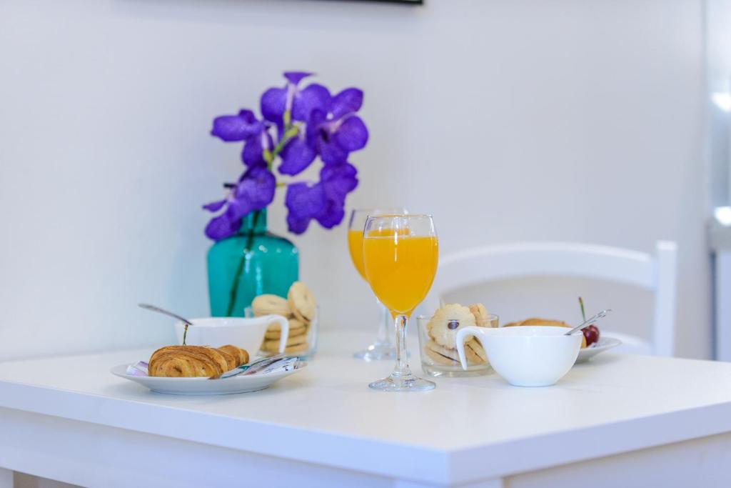 a table with a glass of orange juice and a bowl of croissants at Jadranka studio apartments in Dubrovnik