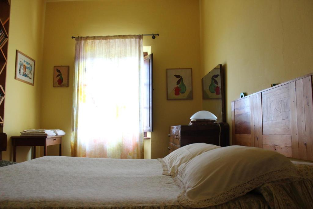 聖吉米納諾的住宿－Bio Agriturismo Podere Pretoia，一间卧室设有一张大床和一个窗户。