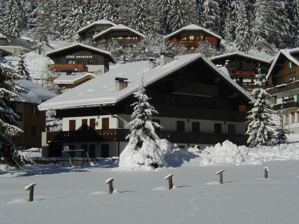 un rifugio da sci con neve sul terreno di fronte ad esso di Aliza a Campitello di Fassa