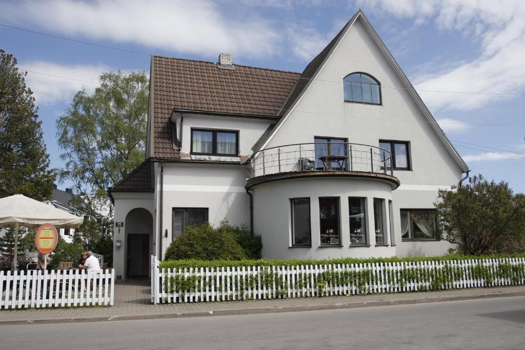 una casa blanca con una valla blanca en Villa Marleen, en Pärnu