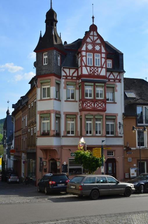 a tall building with cars parked in front of it at BG Living & Hosting - Stilvolles Jugendstilhaus am Marktplatz - Top-Lage im Zentrum in Traben-Trarbach