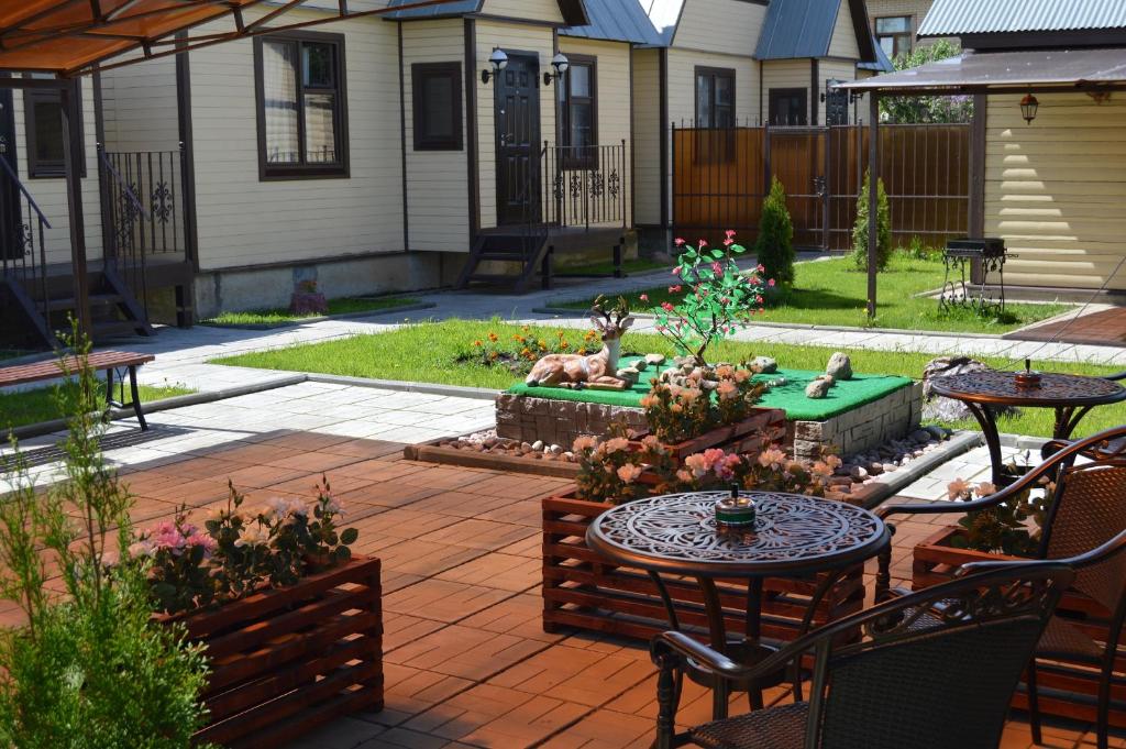 a patio with a table and chairs and a garden at Комплекс Спасатель in Kartino