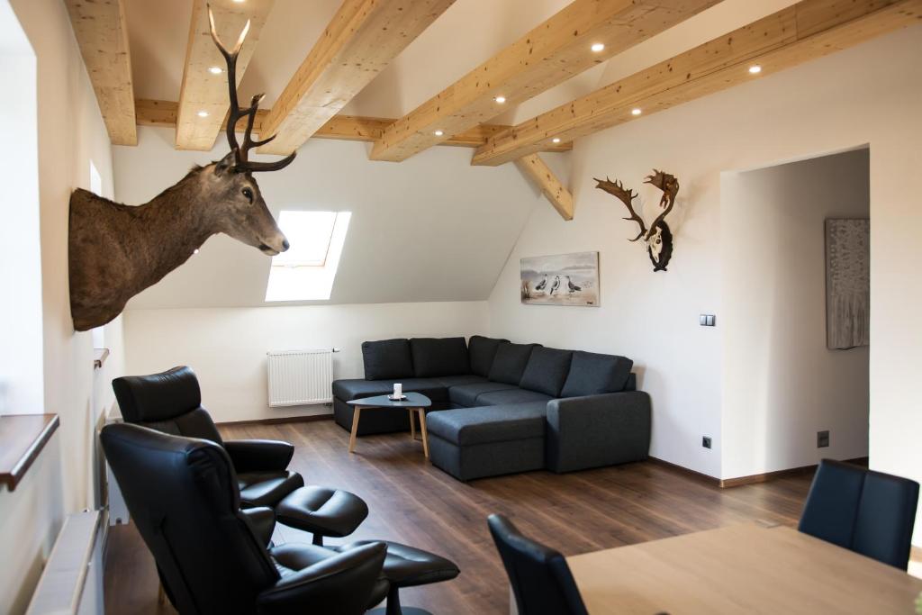 a living room with a couch and a deer head on the wall at Hotel Hubert in Slavonice