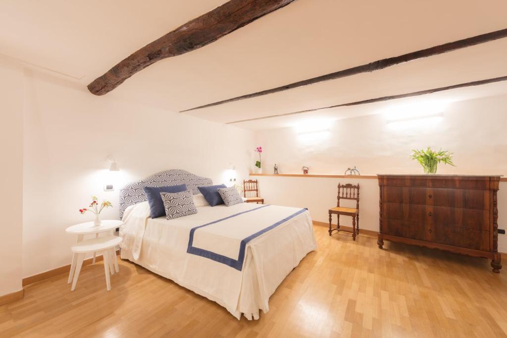 a white bedroom with a bed and a wooden floor at Dimore De Luca in Amalfi