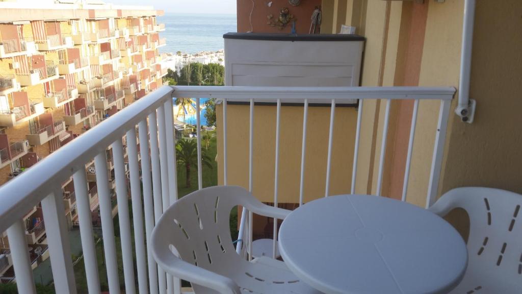 ベナルマデナにあるApartamentos Aguila Minervaの白いテーブルと椅子、海を望むバルコニー