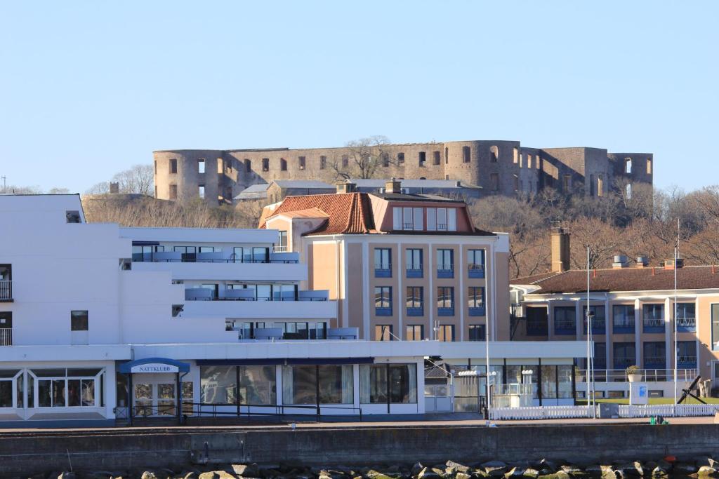 un groupe de bâtiments ayant une ville en arrière-plan dans l'établissement Strand Hotell Borgholm, à Borgholm