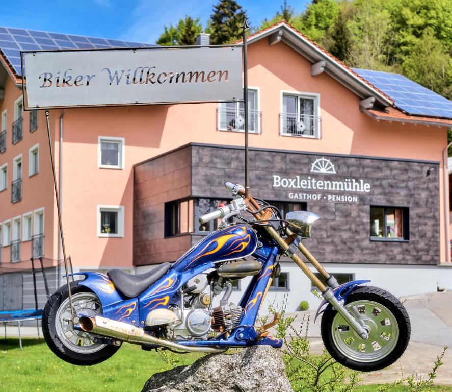 een motorfiets geparkeerd op een rots voor een gebouw bij Gasthof-Pension Boxleitenmühle in Waldkirchen